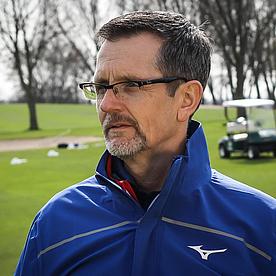 Ein erfahrener Golfer in blau-weißer Jacke auf einem Green des Förde-Golf-Clubs.